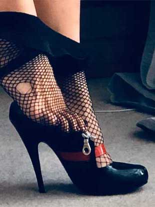 Dominatrix Madame Li Ying dresses for her kinky day, in gag sandals and fishnet nylons