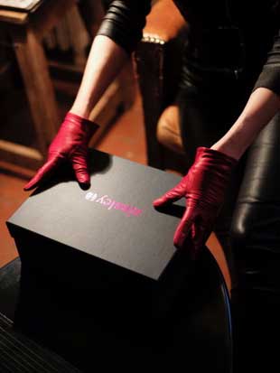 Leather gloved hands holding a shoe box